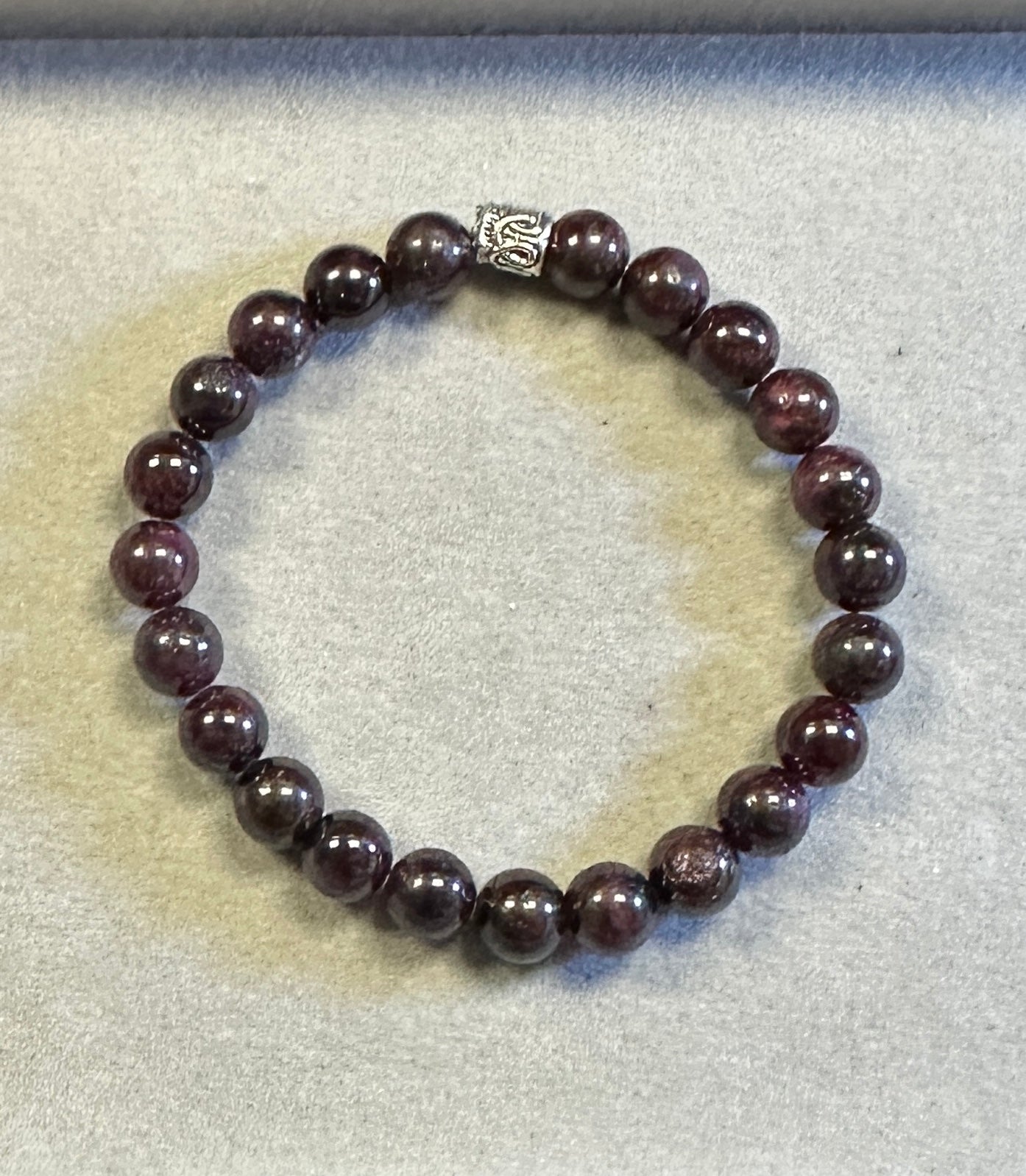 Beaded bracelet with a silver clasp on a textured surface