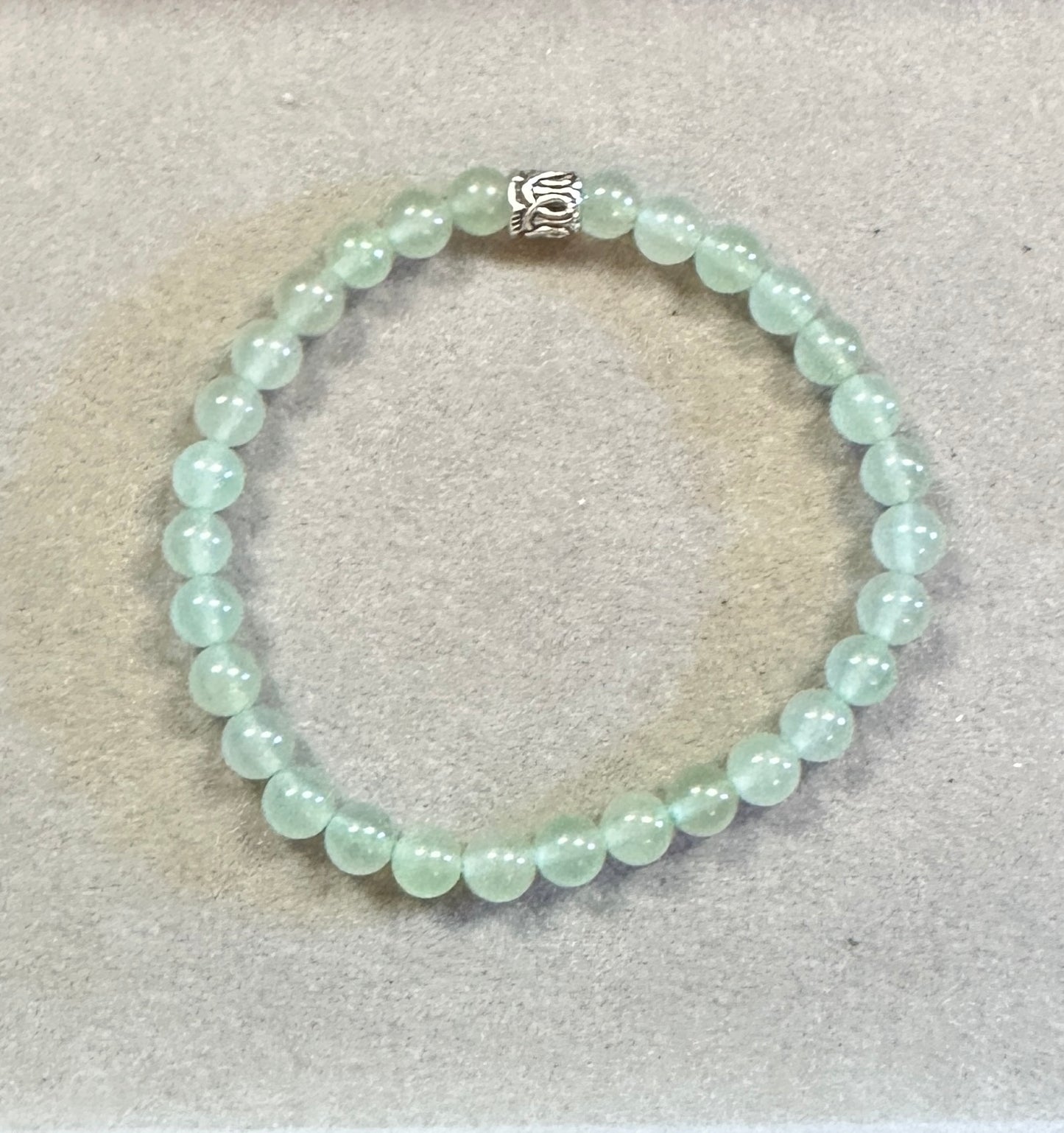 Beaded bracelet with a silver clasp on a light gray background