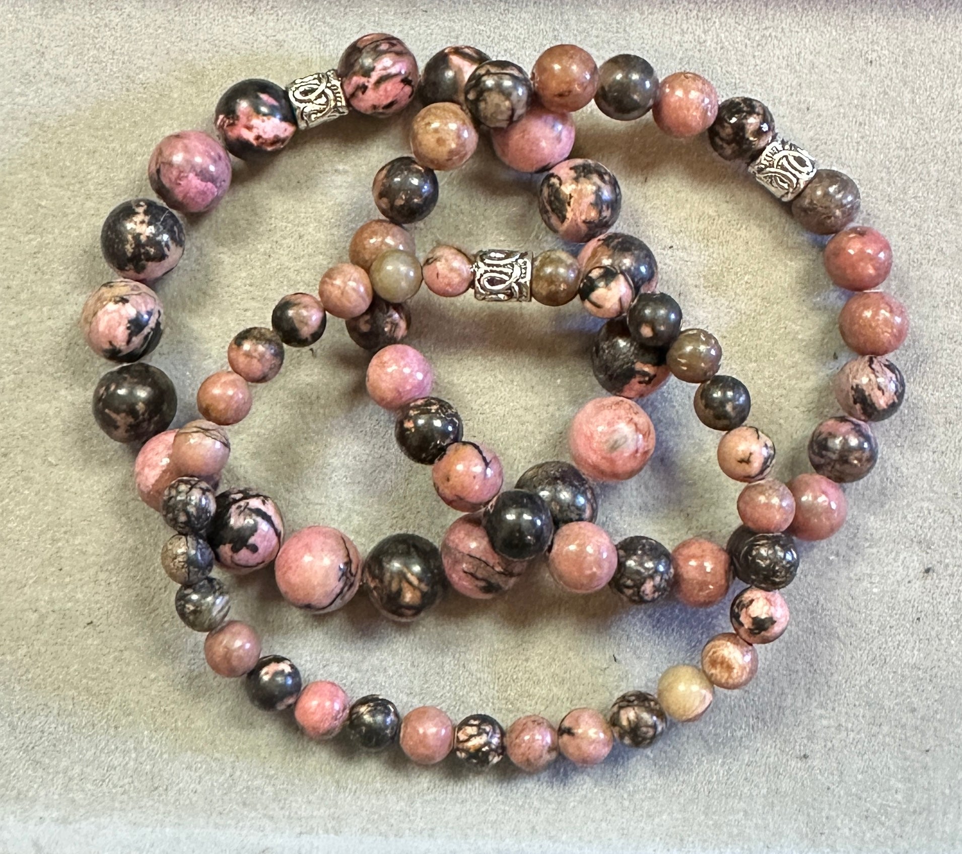 Two beaded bracelets with pink and brown stones on a light gray background