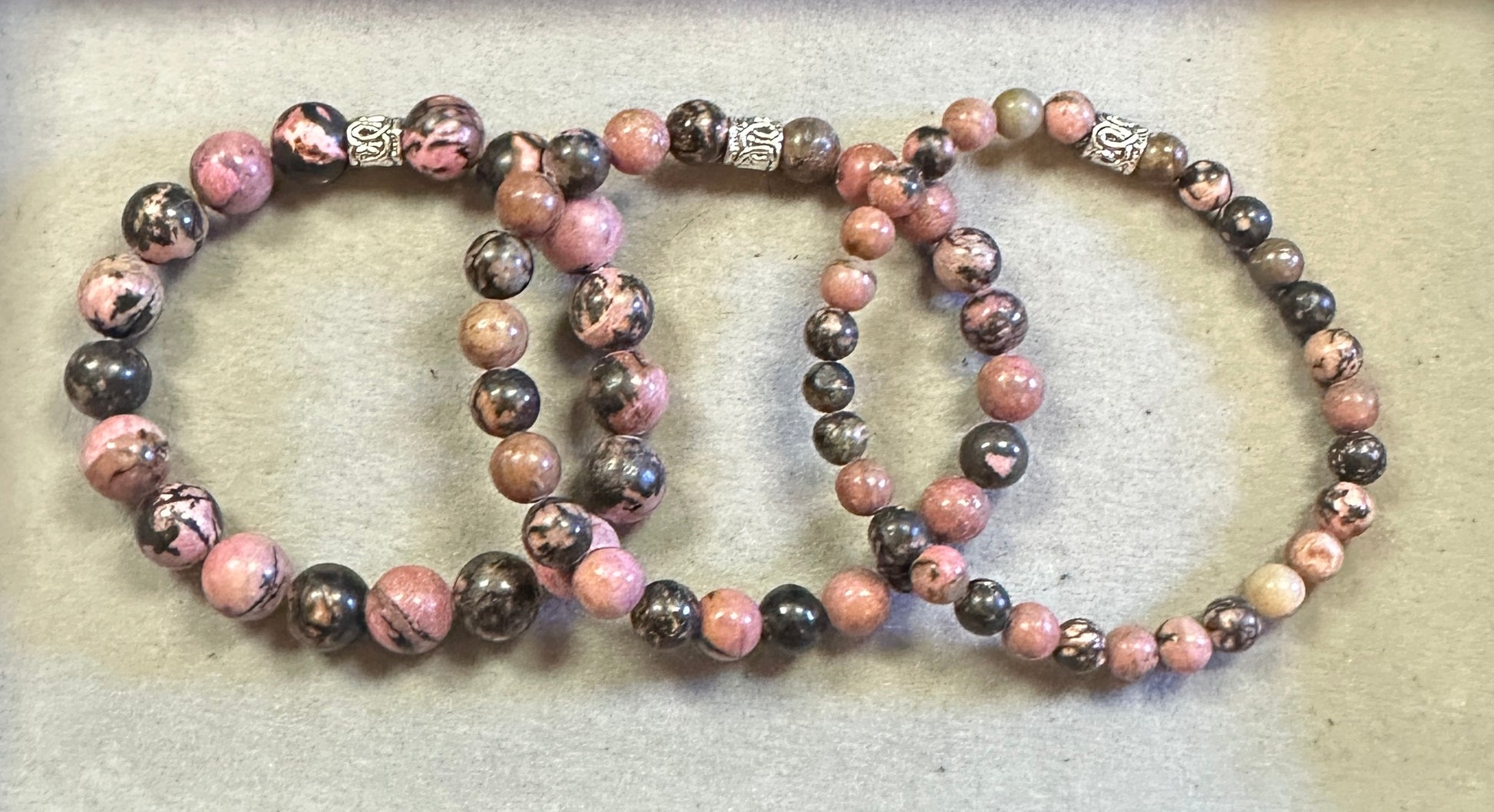 Three beaded bracelets on a textured surface