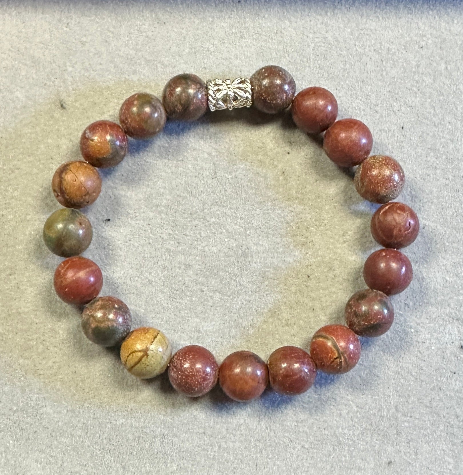 Bracelet with brown marbled beads on a textured surface