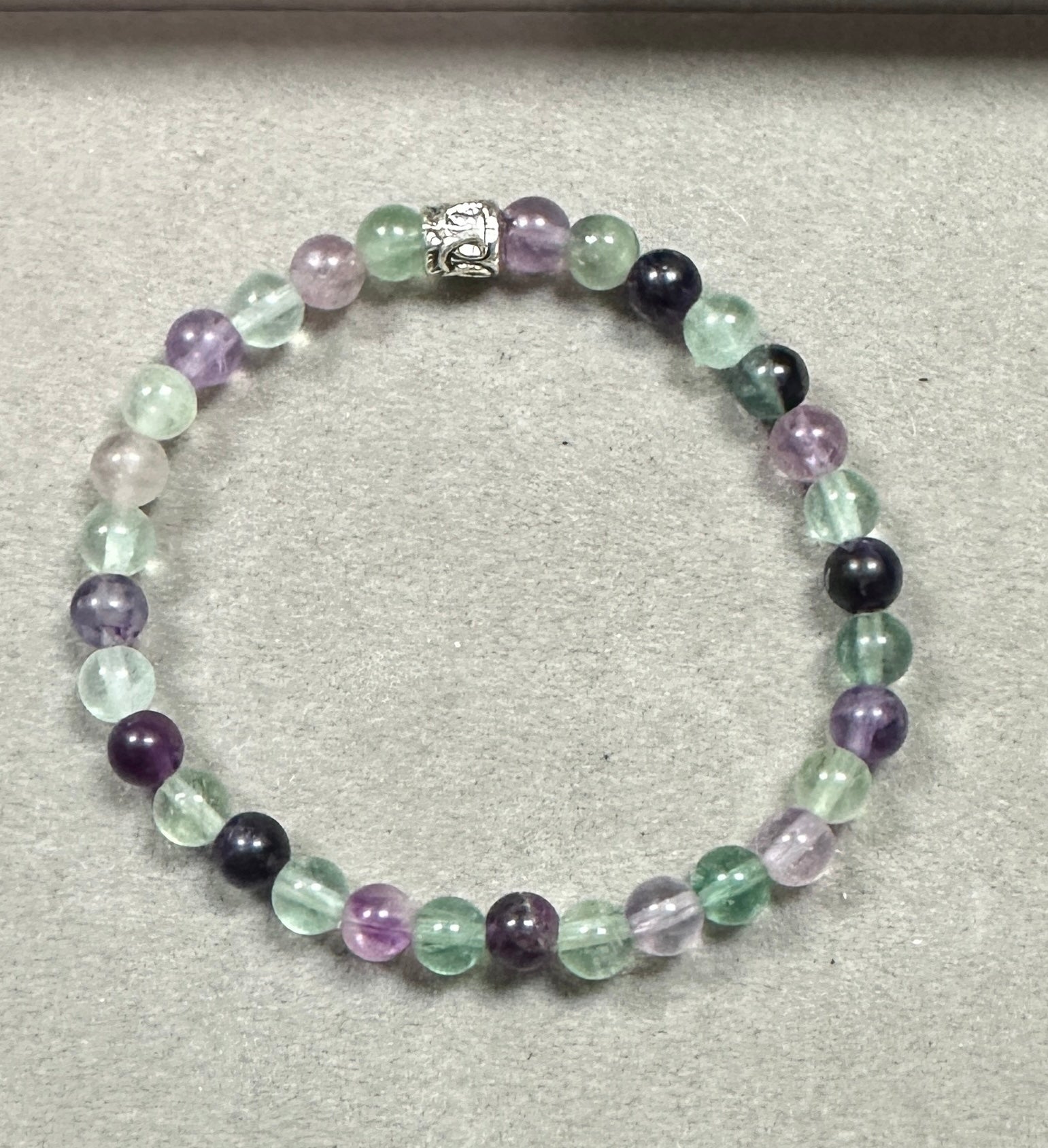 Beaded bracelet with multicolored beads on a gray background