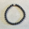 Beaded bracelet with a silver clasp on a light gray background
