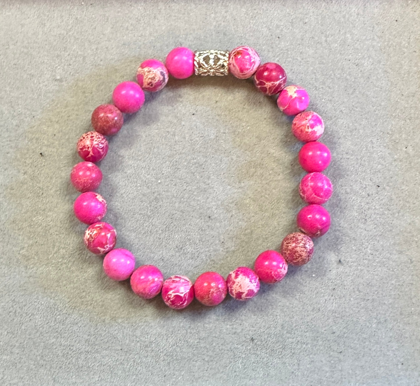 Pink beaded bracelet on a light gray background