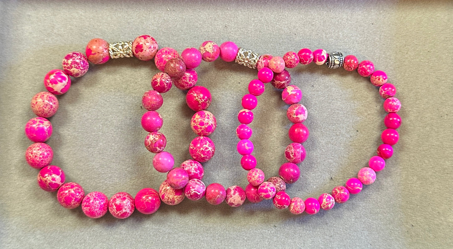 Two pink beaded bracelets on a beige background
