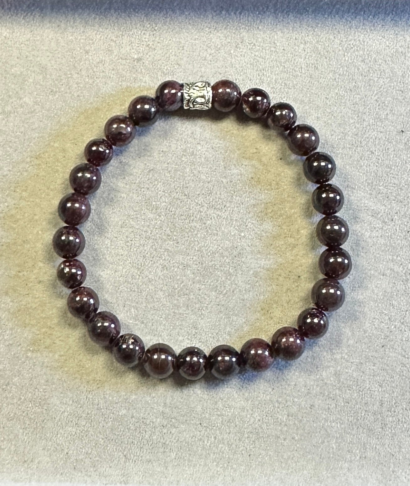 Beaded bracelet with a silver clasp on a light gray background