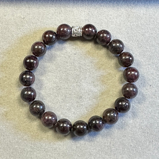 Bracelet with dark beads on a light gray background